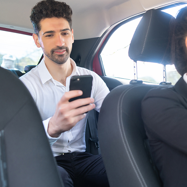 businessman using mobile phone in car.